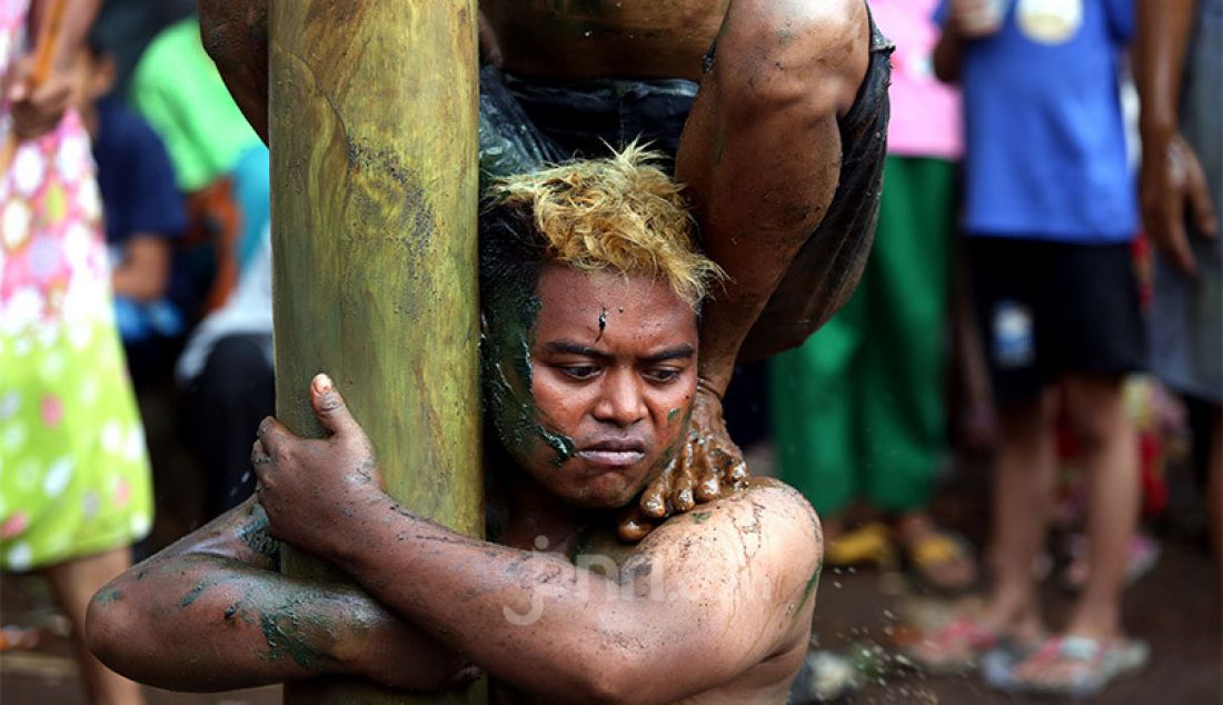 Sejumlah remaja mengikuti lomba panjat pinang di Kampung Pasir Jambu, Kecamatan Sukaraja, Kabupaten Bogor, Senin (17/8). Lomba panjat pinang menjadi salah satu tradisi yang tak pernah terlewatkan di setiap perayaan Hari Kemerdekaan Republik Indonesia. Perlombaan yang menantang fisik dan adu strategi ini selalu menghadirkan hadiah menarik untuk diperebutkan warga. - JPNN.com