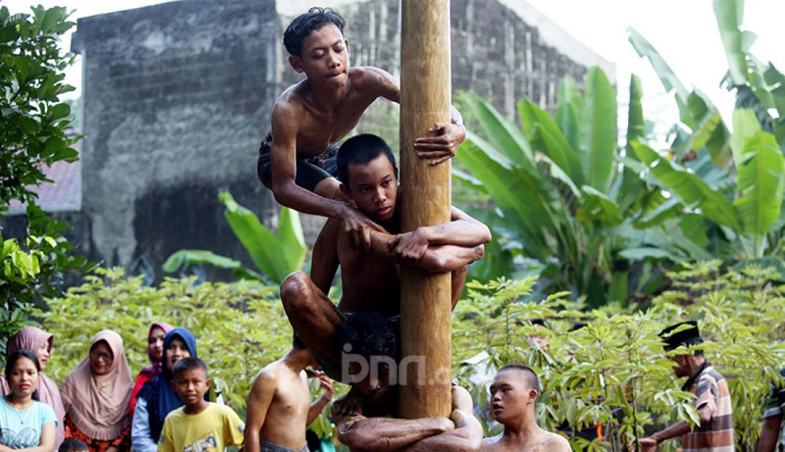 Sejumlah remaja mengikuti lomba panjat pinang di Kampung Pasir Jambu, Kecamatan Sukaraja, Kabupaten Bogor, Senin (17/8). Lomba panjat pinang menjadi salah satu tradisi yang tak pernah terlewatkan di setiap perayaan Hari Kemerdekaan Republik Indonesia. Perlombaan yang menantang fisik dan adu strategi ini selalu menghadirkan hadiah menarik untuk diperebutkan warga. - JPNN.com