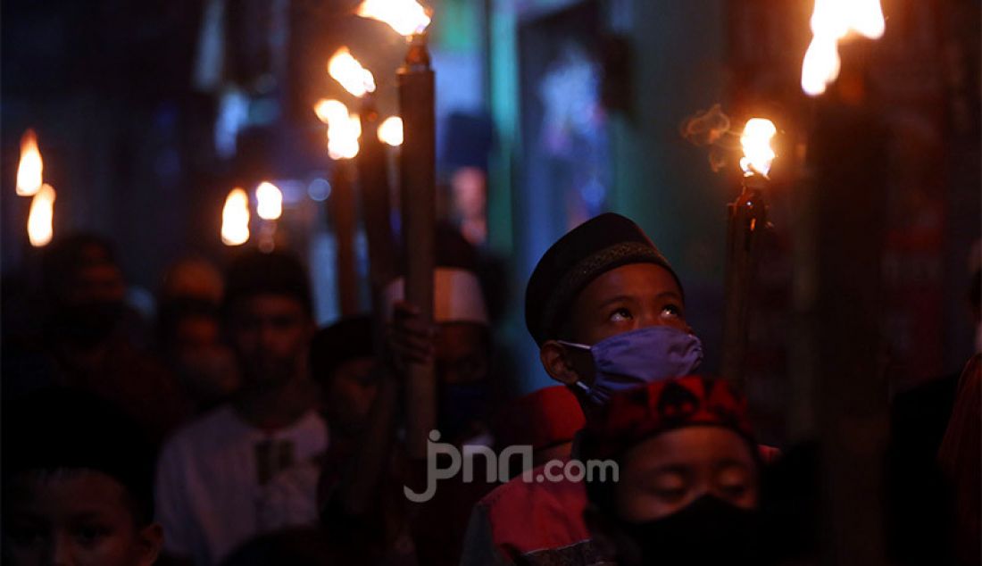 Warga beramai-ramai melakukan pawai obor saat peringatan malam 1 Muharram 1442 H di kawasan Rempoa, Ciputat, Tangerang Selatan, Rabu (19/8). Kegiatan Gema Muharram tersebut diisi dengan berbagai kegiatan lomba, pawai obor dan permainan tradisional sepakbola api yang rutin diadakan warga untuk menjaga kerukunan dan menyambut pergantian Tahun Baru Islam. - JPNN.com