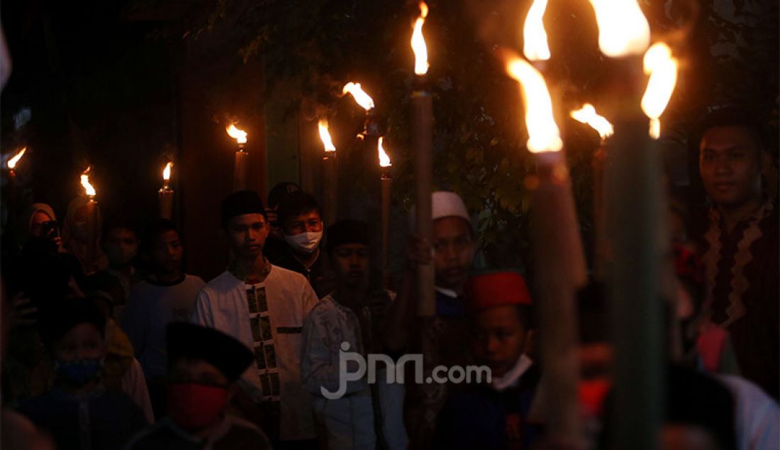 Warga beramai-ramai melakukan pawai obor saat peringatan malam 1 Muharram 1442 H di kawasan Rempoa, Ciputat, Tangerang Selatan, Rabu (19/8). Kegiatan Gema Muharram tersebut diisi dengan berbagai kegiatan lomba, pawai obor dan permainan tradisional sepakbola api yang rutin diadakan warga untuk menjaga kerukunan dan menyambut pergantian Tahun Baru Islam. - JPNN.com