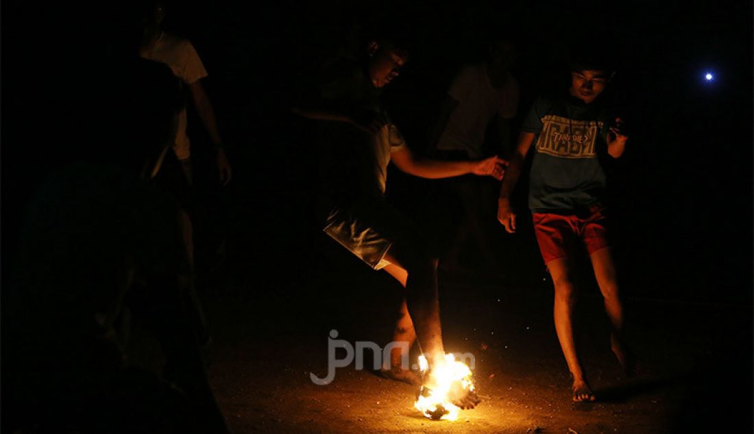 Warga bermain bola api saat peringatan malam 1 Muharram 1442 H di kawasan Rempoa, Ciputat, Tangerang Selatan, Rabu (19/8). Kegiatan Gema Muharram tersebut diisi dengan berbagai kegiatan lomba, pawai obor dan permainan tradisional sepakbola api yang rutin diadakan warga untuk menjaga kerukunan dan menyambut pergantian Tahun Baru Islam. - JPNN.com