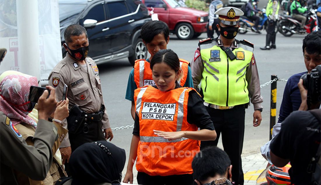 Warga terjaring razia PSBB di Jalan Raya Cinere, Depok, Senin (24/8). Razia ditujukan kepada warga yang tidak mengenakan masker dengan memberikan hukuman sosial atau denda bertujuan menekan penyebaran virus covid-19 di wilayah Depok yang saat ini kembali menjadi zona merah. - JPNN.com