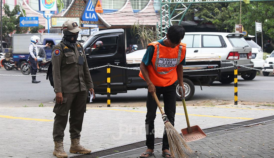 Warga yang terjaring razia PSBB diberikan sanksi sosial berupa membersihkan jalanan kota Depok, Senin (24/8). Razia ditujukan kepada warga yang tidak mengenakan masker dengan memberikan hukuman sosial atau denda bertujuan menekan penyebaran virus covid-19 di wilayah Depok yang saat ini kembali menjadi zona merah. - JPNN.com