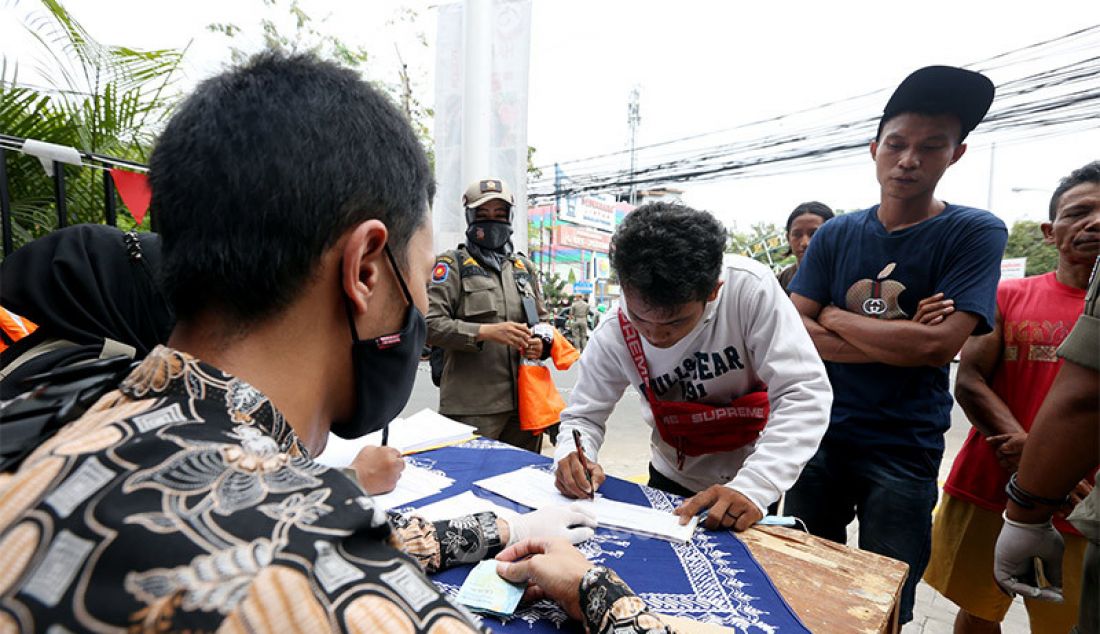 Petugas mendata warga yang terjaring razia PSBB di Jalan Raya Cinere, Depok, Senin (24/8). Razia ditujukan kepada warga yang tidak mengenakan masker dengan memberikan hukuman sosial atau denda bertujuan menekan penyebaran virus covid-19 di wilayah Depok yang saat ini kembali menjadi zona merah. - JPNN.com