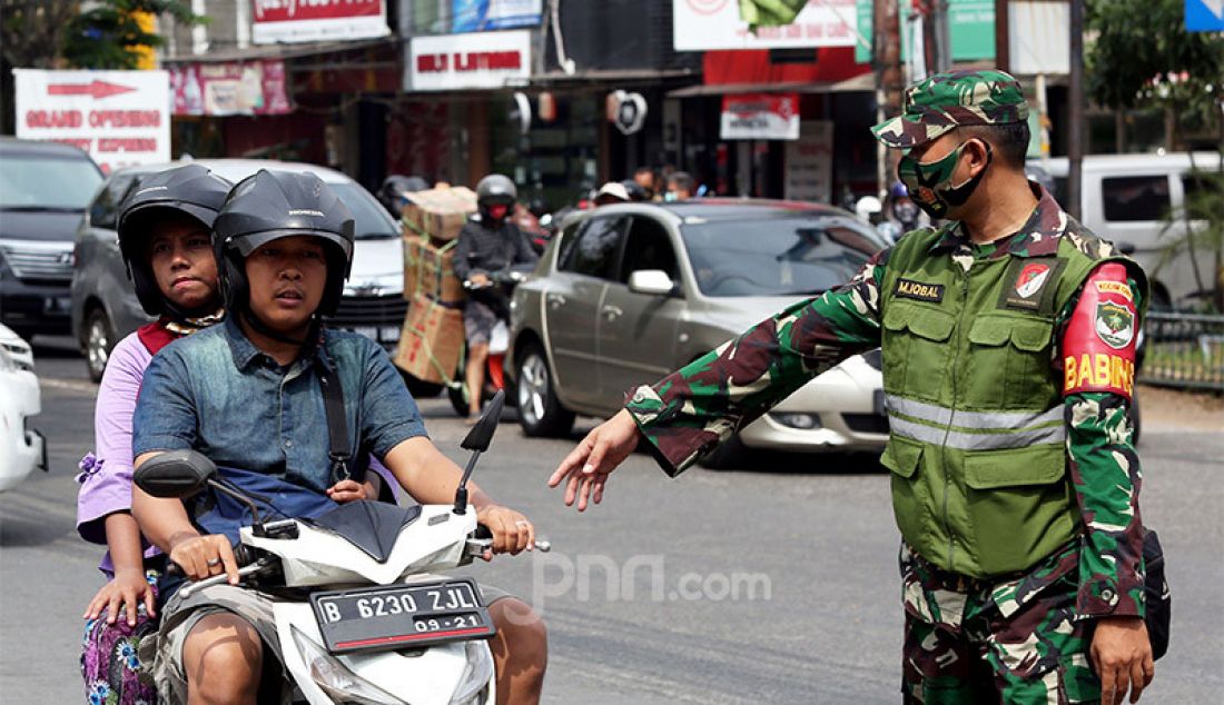 Petugas gabungan melakukan razia PSBB di Jalan Raya Cinere, Depok, Senin (24/8). Razia ditujukan kepada warga yang tidak mengenakan masker dengan memberikan hukuman sosial atau denda bertujuan menekan penyebaran virus covid-19 di wilayah Depok yang saat ini kembali menjadi zona merah. - JPNN.com