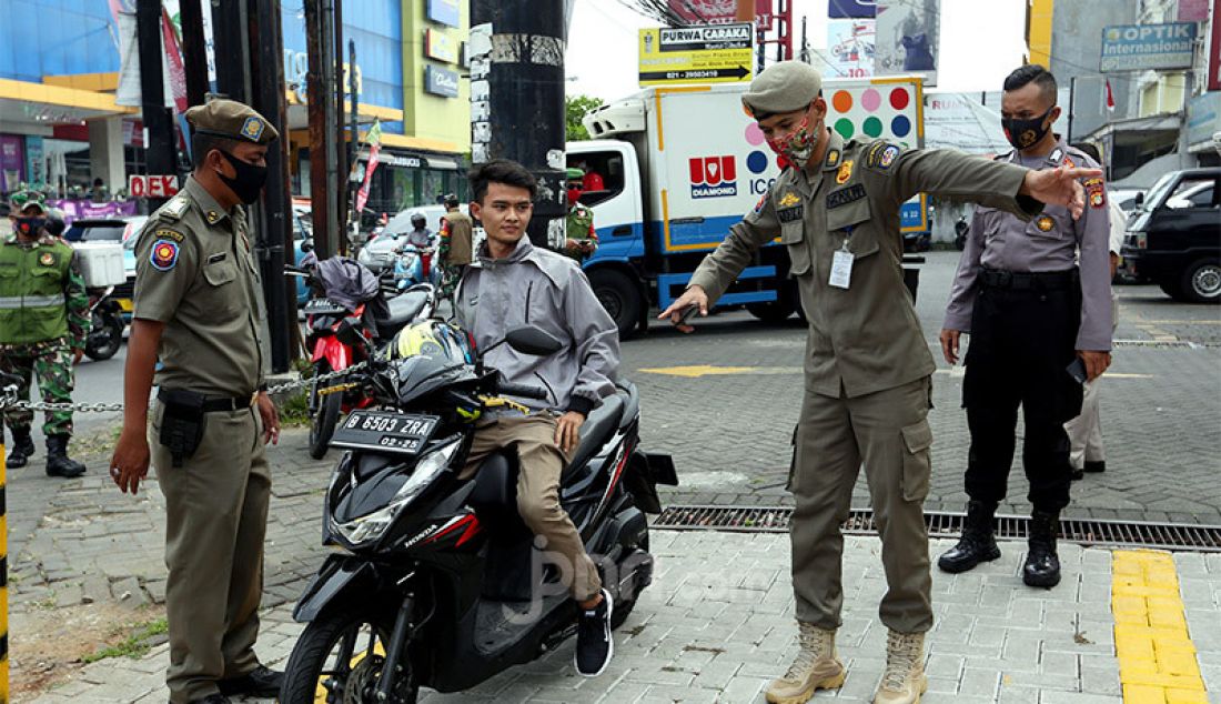 Petugas gabungan melakukan razia PSBB di Jalan Raya Cinere, Depok, Senin (24/8). Razia ditujukan kepada warga yang tidak mengenakan masker dengan memberikan hukuman sosial atau denda bertujuan menekan penyebaran virus covid-19 di wilayah Depok yang saat ini kembali menjadi zona merah. - JPNN.com