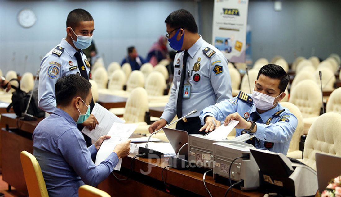 Petugas Imigrasi melayani staff dan anggota DPR dalam proses pembuatan pasport di komplek Parlemen, Senayan, Jakarta, Selasa, (25/8). Layanan eazy pasport dari Imigrasi Jakarta Selatan melayani pembuatan dan perpanjangan pasport dengan cara menjemput bola bagi anggota DPR RI dalam rangka kemudahan pelayanan untuk masyarakat. - JPNN.com