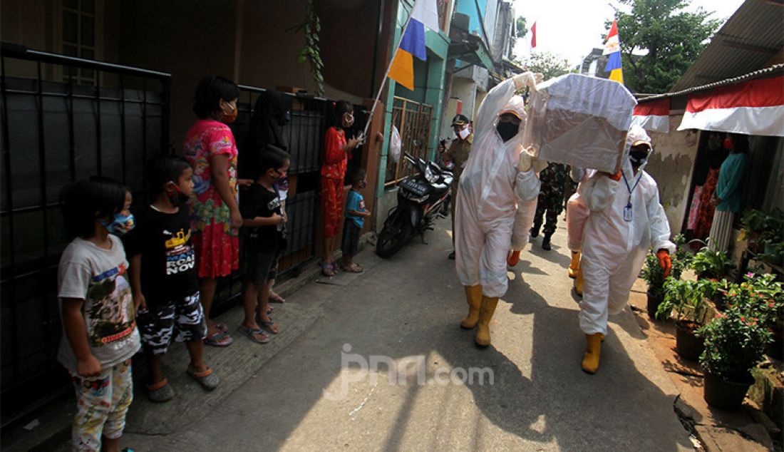 Petugas Kecamatan Cilandak membawa peti jenazah saat melakukan kampanye bahaya COVID-19 ke pemukiman warga, Jakarta, Selasa (1/9). Kampanye ini untuk mengimbau sekaligus mengajak masyarakat untuk selalu melakukan gerakan 3M yaitu Menggunakan Masker, Mencuci Tangan dan Menjaga Jarak. - JPNN.com