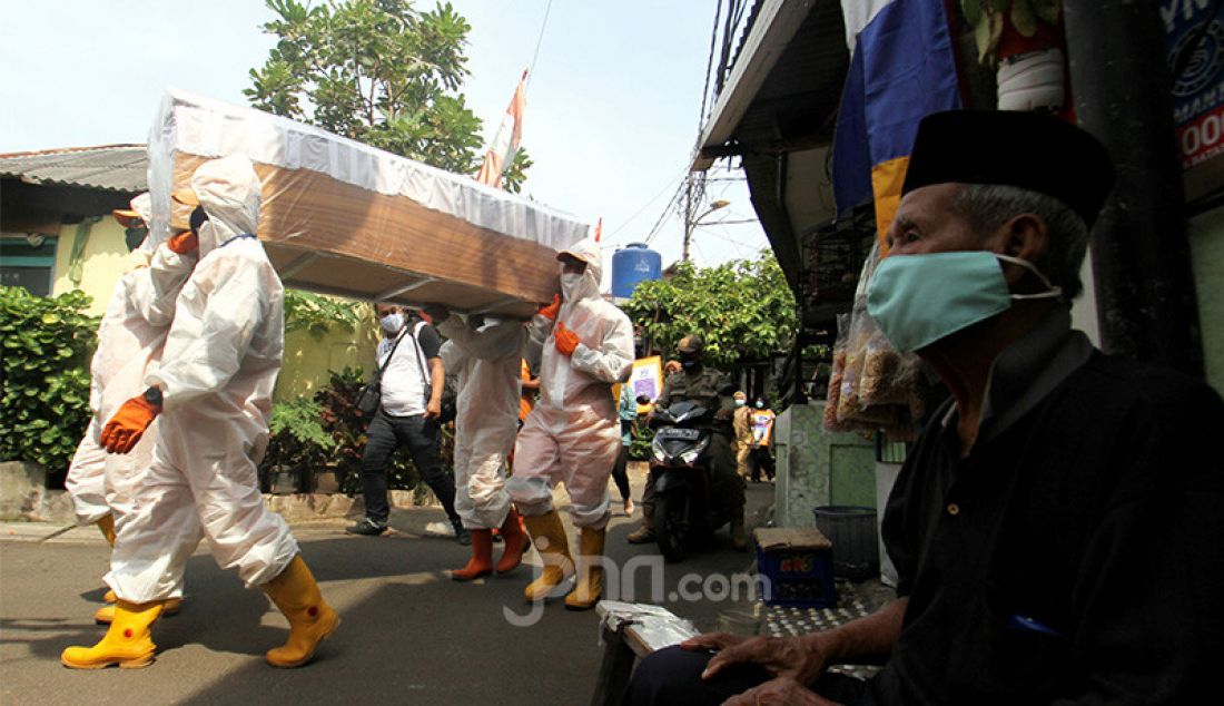 Petugas Kecamatan Cilandak membawa peti jenazah saat melakukan kampanye bahaya COVID-19 ke pemukiman warga, Jakarta, Selasa (1/9). Kampanye ini untuk mengimbau sekaligus mengajak masyarakat untuk selalu melakukan gerakan 3M yaitu Menggunakan Masker, Mencuci Tangan dan Menjaga Jarak. - JPNN.com