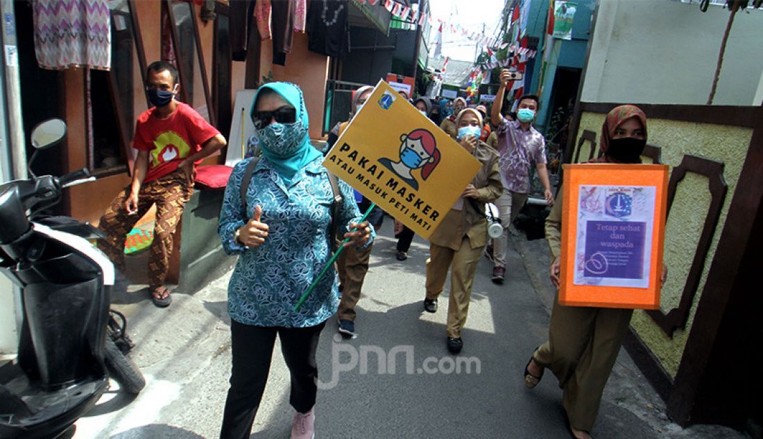 Petugas Kecamatan Cilandak membawa peti jenazah saat melakukan kampanye bahaya COVID-19 ke pemukiman warga, Jakarta, Selasa (1/9). Kampanye ini untuk mengimbau sekaligus mengajak masyarakat untuk selalu melakukan gerakan 3M yaitu Menggunakan Masker, Mencuci Tangan dan Menjaga Jarak. - JPNN.com