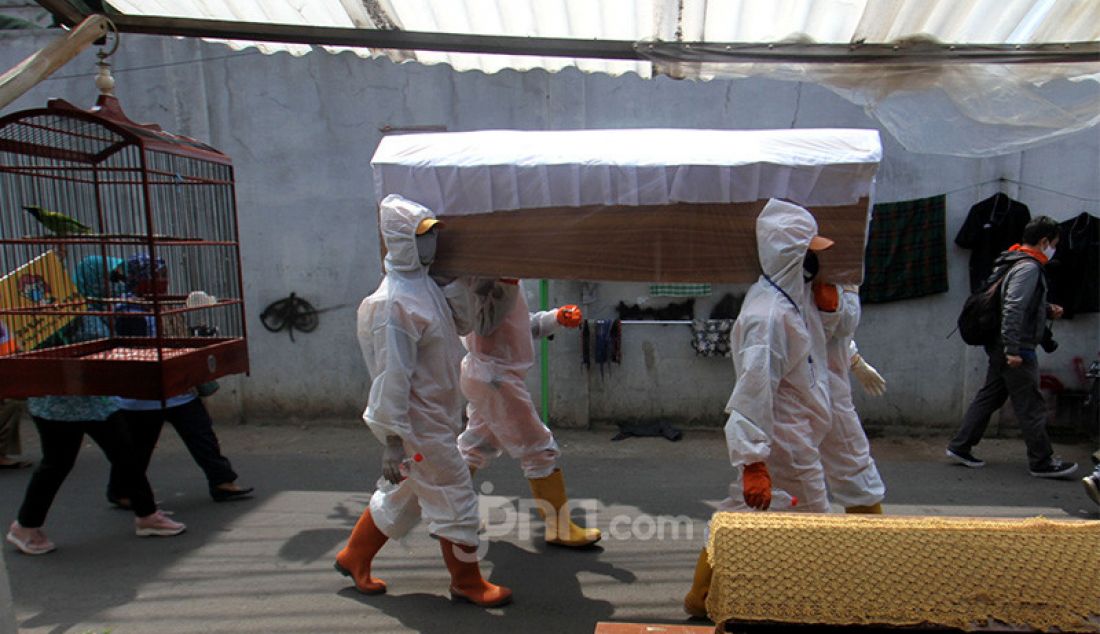 Petugas Kecamatan Cilandak membawa peti jenazah saat melakukan kampanye bahaya COVID-19 ke pemukiman warga, Jakarta, Selasa (1/9). Kampanye ini untuk mengimbau sekaligus mengajak masyarakat untuk selalu melakukan gerakan 3M yaitu Menggunakan Masker, Mencuci Tangan dan Menjaga Jarak. - JPNN.com