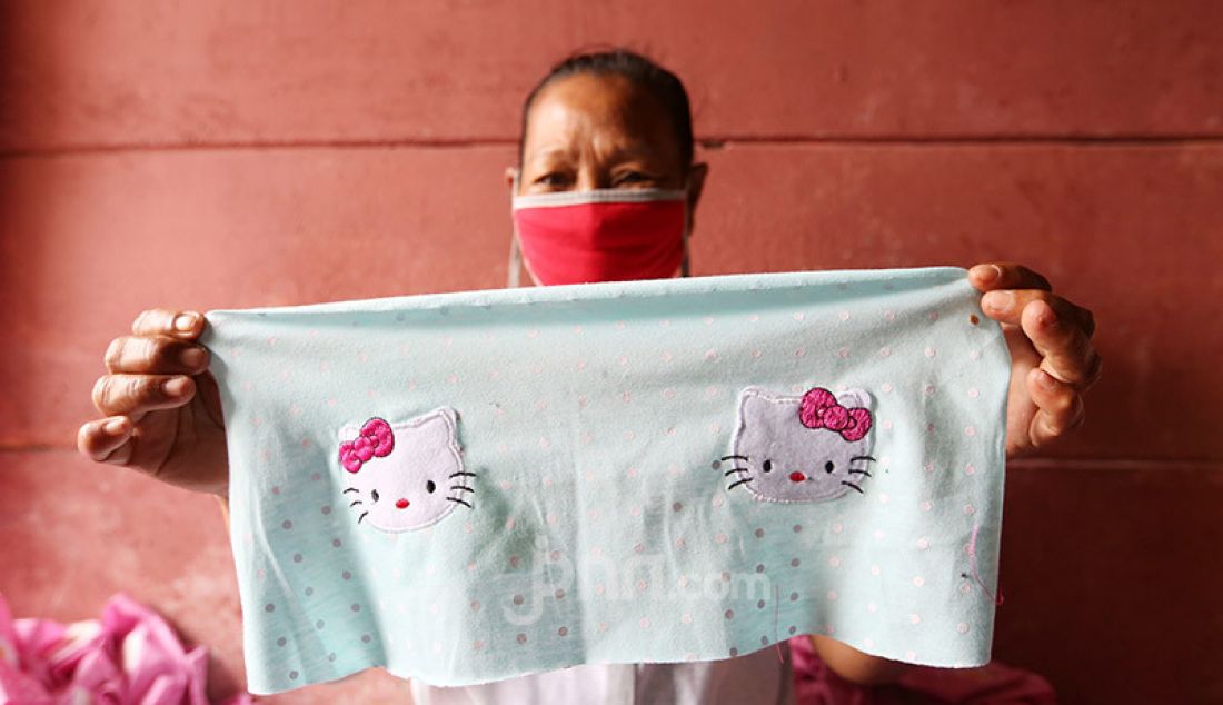 Seorang warga menunjukkan hasil pembuatan pakaian bayi di Kelurahan Pademangan Barat, Jakarta Utara, Rabu (2/9). Omset pembuatan pakaian bayi yang bahannya dipasok dari perusahaan konfeksi ini mengalami penurunan selama pandemi. - JPNN.com