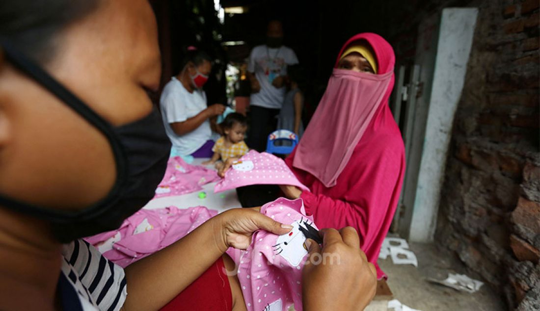 Sejumlah warga saat menyelesaikan pembuatan pakaian bayi di Kelurahan Pademangan Barat, Jakarta Utara, Rabu (2/9). Omset pembuatan pakaian bayi yang bahannya dipasok dari perusahaan konfeksi ini mengalami penurunan selama pandemi. - JPNN.com