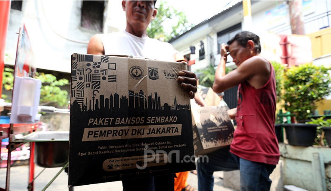 Warga menurunkan 562 paket bantuan sosial (bansos) dari Pemprov DKI Jakarta di Posko RW 13, Kelurahan Pademangan Barat, Jakarta Utara, Rabu (2/9). Paket bantuan tersebut berisi beras 5 kilogram, 4 kaleng sarden, 1 kaleng biskuit, minyak goreng, kecap, 1 kilogram tepung terigu, bihun dan sabun mandi. - JPNN.com