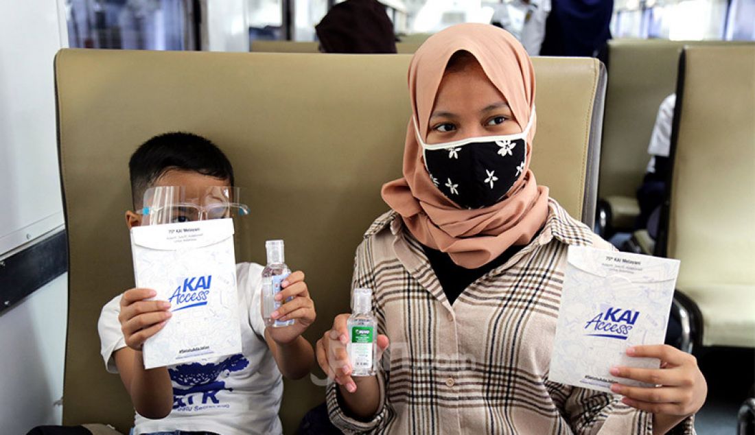 Penumpang kereta api di Stasiun Pasar Senen, Jakarta Pusat menunjukkan masker dan hand sanitizer pemberian PT KAI, Senin (28/9). PT KAI membagi-bagikan masker dan hand sanitizer secara gratis kepada para penumpang kereta dalam rangka peringatan ulang tahunnya yang ke-75. - JPNN.com