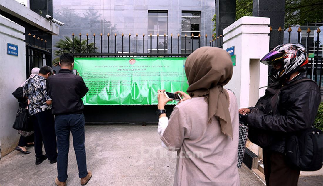 Sejumlah penggunjung Pengadilan Negeri Jakarta Pusat (PN Jakpus) di Jakarta, Rabu (7/10) membaca pengumuman di pagar terkait penutupan sementara pada 7-9 Oktober 2020. PN Jakpus melakukan lockdown selama 3 hari setelah ada pegawainya yang terjangkiti Covid-19. - JPNN.com