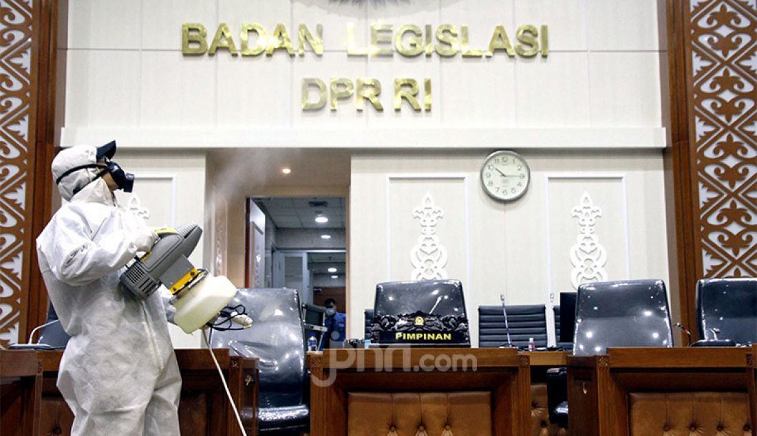 Petugas yang mengenakan pakaian hazardous materials (hazmat suit) menyemprotkan cairan disinfektan di ruang Badan Legislasi (Baleg) DPR RI, Kompleks Parlemen Senayan, Jakarta, Senin (12/10). Penyemprotan disinfektan dan sterilisasi itu sebagai tindak lanjut atas kasus Covid-19 yang menjangkiti 18 anggota DPR. - JPNN.com