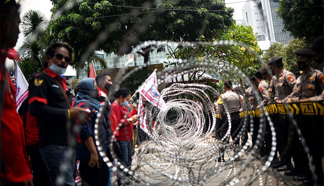 Massa dari Konfederasi Serikat Pekerja Indonesia (KSPI) yang berunjuk rasa menolak Omnibus Law Cipta Kerja di Jalan Medan Merdeka Barat, Jakarta Pusat, Senin (12/1) berhadap-hadapan dengan anggota kepolisian. - JPNN.com