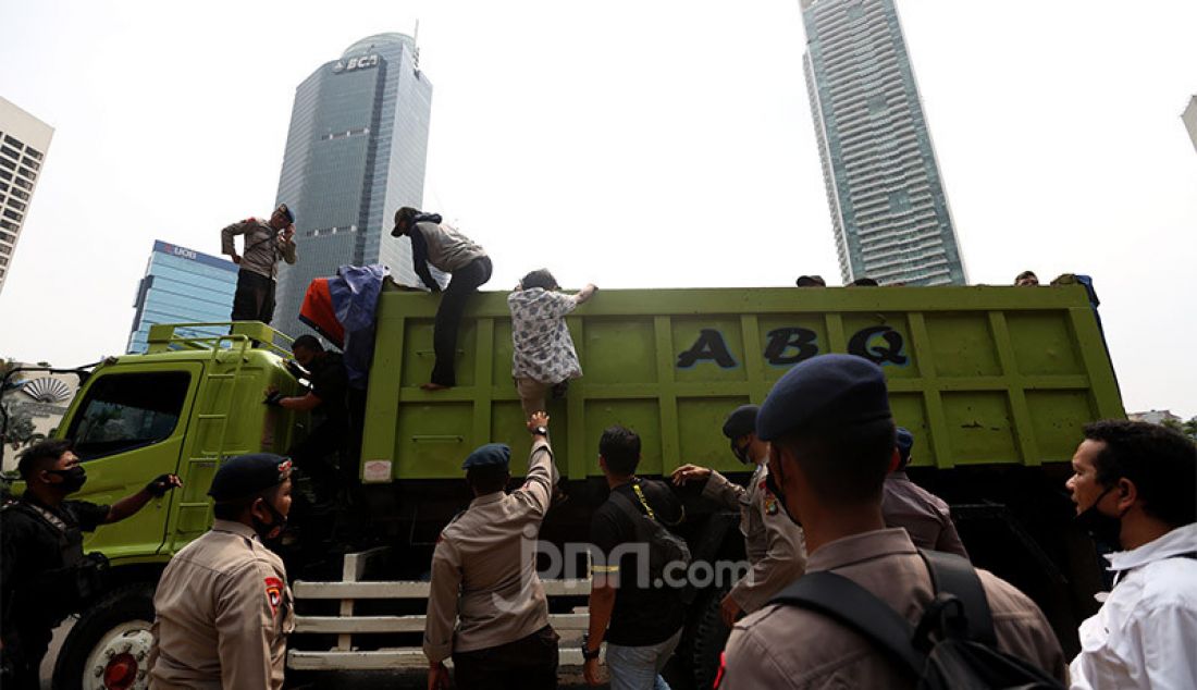 Petugas kepolisian memberhentikan sebuah truk yang melintas di kawasan Bundaran HI, Jakarta Pusat, Selasa (13/10). Polisi mendapati truk itu mengangkut puluhan pelajar yang akan mengikuti unjuk rasa memprotes Omnibus Law Cipta Kerja di kawasan Patung Kuda, Kebon Sirih. - JPNN.com