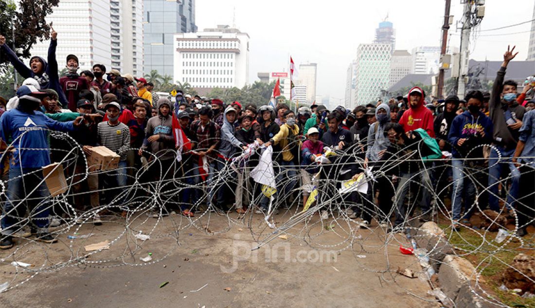 Pedemo pada aksi unjuk rasa menolak Omnibus Law Cipta Kerja merusak pagar kawat yang dipasang petugas di kawasan Kebun Sirih, Jakarta Pusat, Selasa (13/10). - JPNN.com
