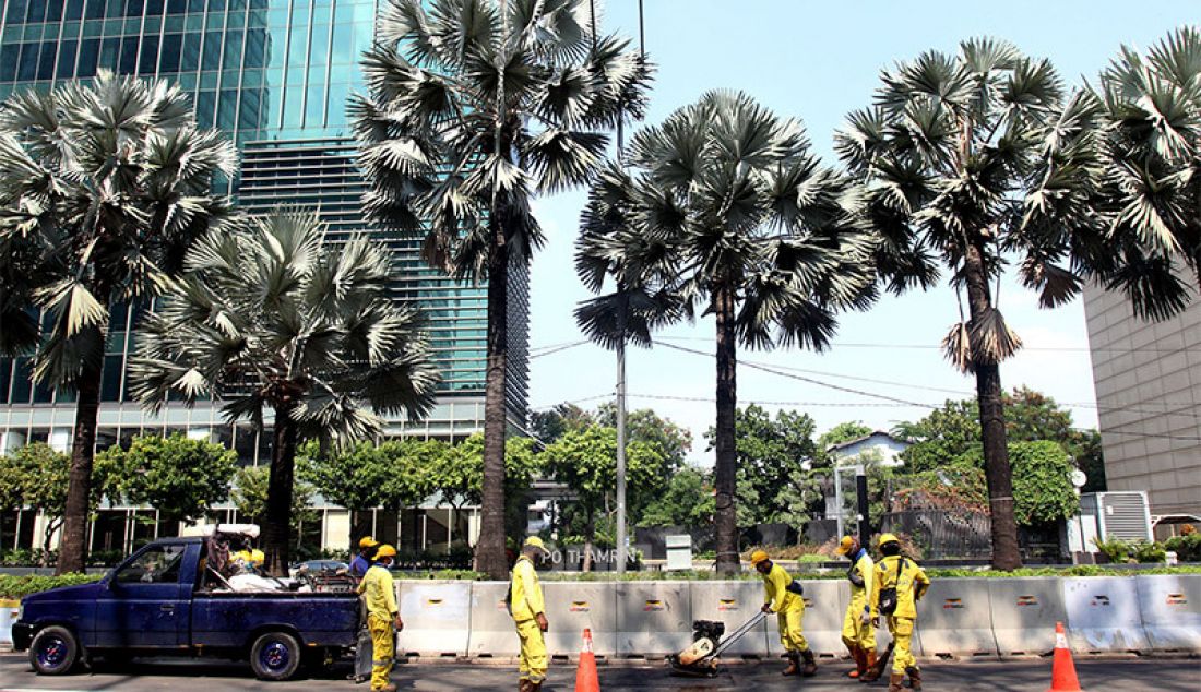 Petugas memperbaikan aspal di Jalan Thamrin, Jakarta Pusat, Rabu (14/1). Aspal di ruas jalan utama ibu kota itu rusak pascademo menolak Omnibus Law Cipta Kerja pada Kamis (8/10) yang berakhir rusuh. - JPNN.com