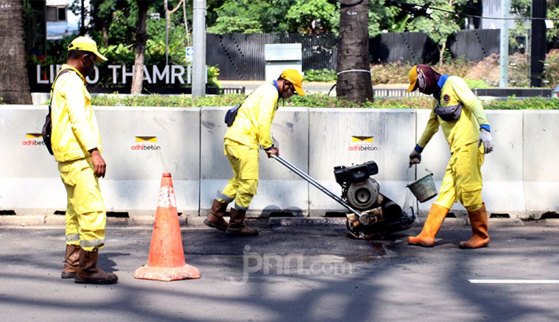 Petugas memperbaikan aspal di Jalan Thamrin, Jakarta Pusat, Rabu (14/1). Aspal di ruas jalan utama ibu kota itu rusak pascademo menolak Omnibus Law Cipta Kerja pada Kamis (8/10) yang berakhir rusuh. - JPNN.com