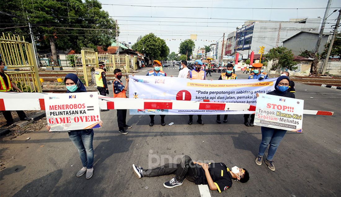 Volunter dari Pecinta Kereta Api bersama PT KAI melakukan sosialisasi pelintasan sebidang di Jalan Garuda, Kemayoran, Jakarta Pusat, Rabu (14/10). - JPNN.com