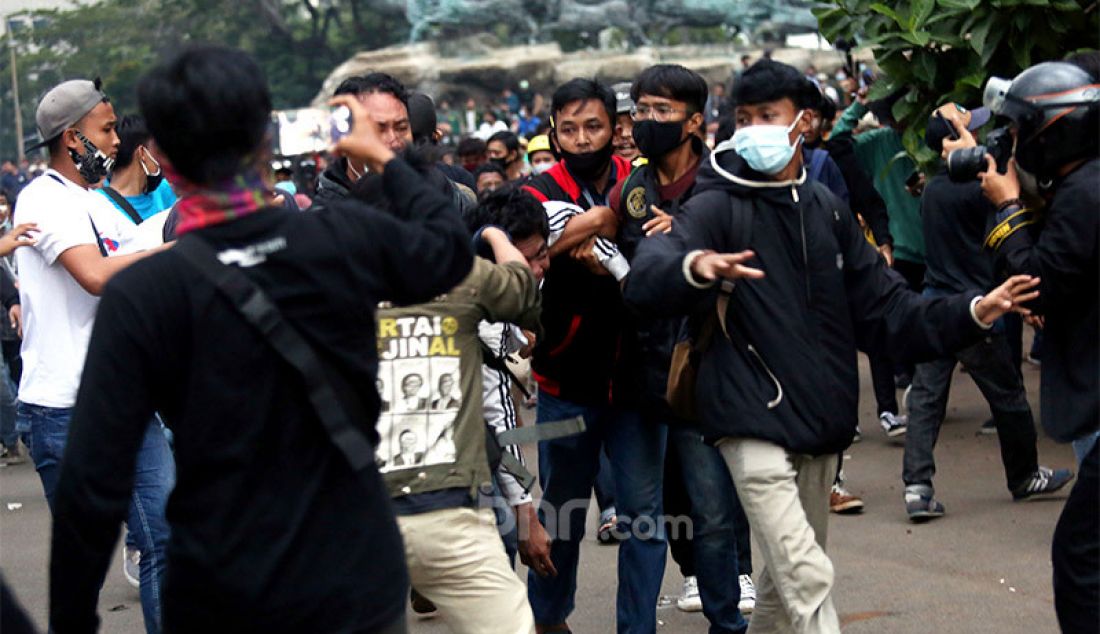 Sejumlah demonstran berusaha menghakimi copet yang diamankan petugas saat aksi unjuk rasa menolak UU Cipta Kerja di sekitar kawasan Patung Kuda, Jalan Medan Merdeka Barat, Jakarta, Selasa (20/10). - JPNN.com