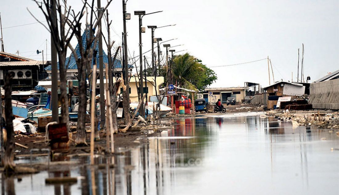 Banjir setinggi mata kaki akibat rob menggenangi jalanan di sekitar tanggul laut di kawasan Muara Baru, Jakarta Utara, Kamis (22/10). Rob itu sebagai akibat tanggul laut yang jebol pada 2019 namun hingga kini belum diperbaiki. - JPNN.com