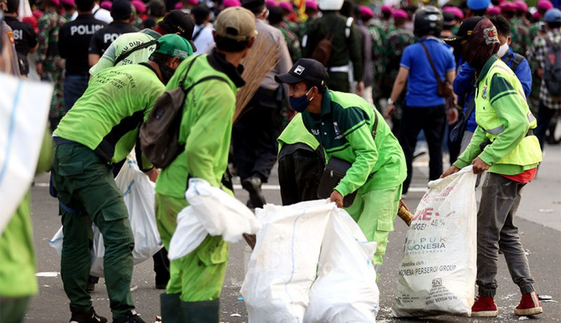 Petugas kebersihan memberikan sampah-sampah usai demo UU Cipta Kerja di Kawasan Patung Kuda, Jakarta, Rabu (28/10). - JPNN.com