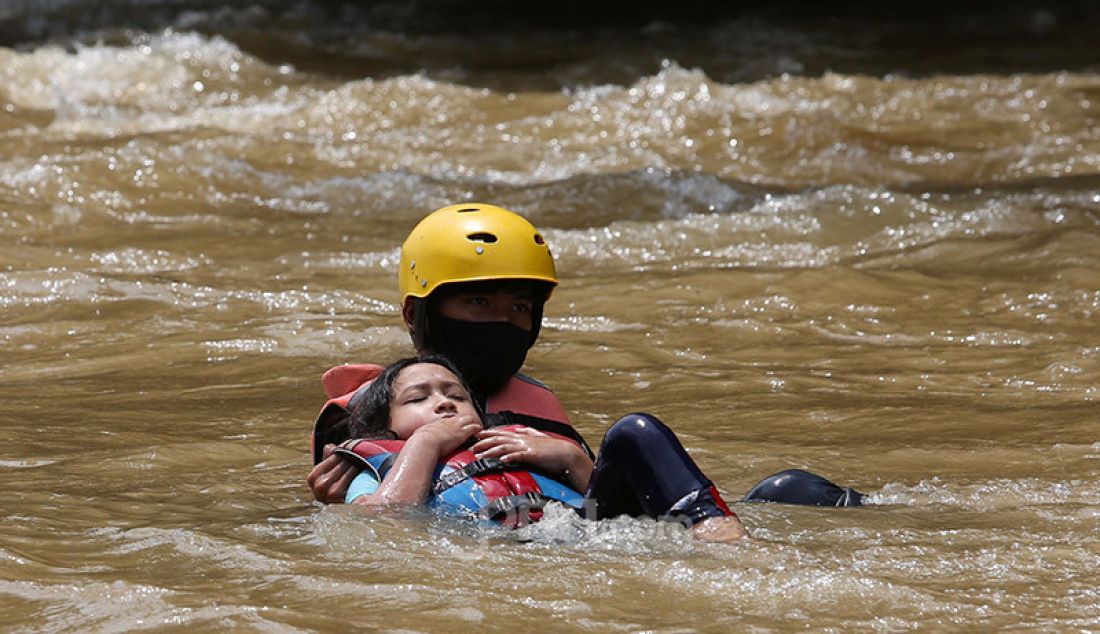 Instruktur Hiking Bocah mendampingi seorang anak yang terjatuh dari perahu karet saat mengikuti rafting di kawasan Bendung Katulampa, Bogor, Kamis (29/10). Kegiatan yang diadakan Hiking Bocah pada setiap akhir pekan atau libur panjang itu dalam rangka mengenalkan lingkungan alam kepada anak-anak. - JPNN.com