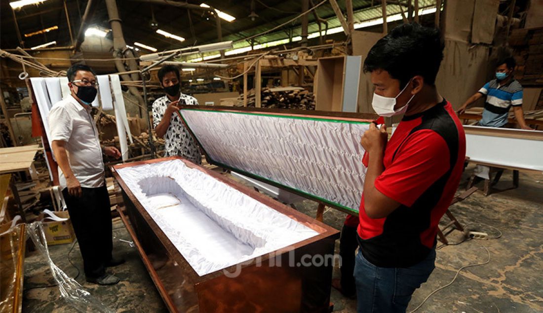 Sejumlah pekerja di pabrik Hakari Furniture, kawasan Daan Mogot, Jakarta Barat, Jumat (30/10) menyelesaikan pesanan peti mati khusus jenazah Covid-19. Hakari Furniture mampu membuat 100 peti mati khusus jenazah korban Covid-19 per hari. - JPNN.com