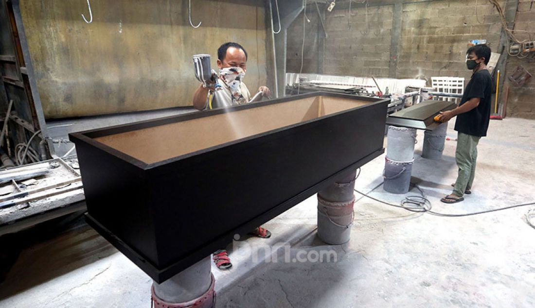 Sejumlah pekerja di pabrik Hakari Furniture, kawasan Daan Mogot, Jakarta Barat, Jumat (30/10) menyelesaikan pesanan peti mati khusus jenazah Covid-19. Hakari Furniture mampu menghasilkan 100 peti mati khusus jenazah korban Covid-19 per hari. - JPNN.com