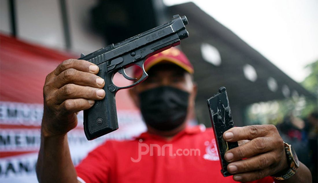 Seorang petugas menunjukkan senjata api jenis pistol yang akan dimusnahkan di halaman Kejaksaan Negeri, Jakarta Utara, Rabu (11/11). Pistol tersebut merupakan barang bukti perkara yang telah diputus pengadilan dan berkekuatan hukum tetap (inkrah). - JPNN.com
