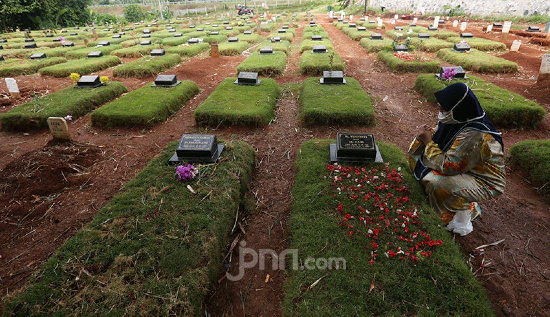 Warga melakukan ziarah kubur korban Covid-19 di Taman Pemakaman Umum (TPU) Jombang, Tangerang Selatan, Banten, Selasa (29/12). Pada Senin (28/12), terdapat 32 kasus baru Covid-19 di Tangsel sehingga totalnya sudah mencapai 3.625 kasus dengan perincian 3.045 orang dinyatakan sembuh, sementara 410 pasien masih dirawat, sedangkan 170 orang meninggal dunia. - JPNN.com