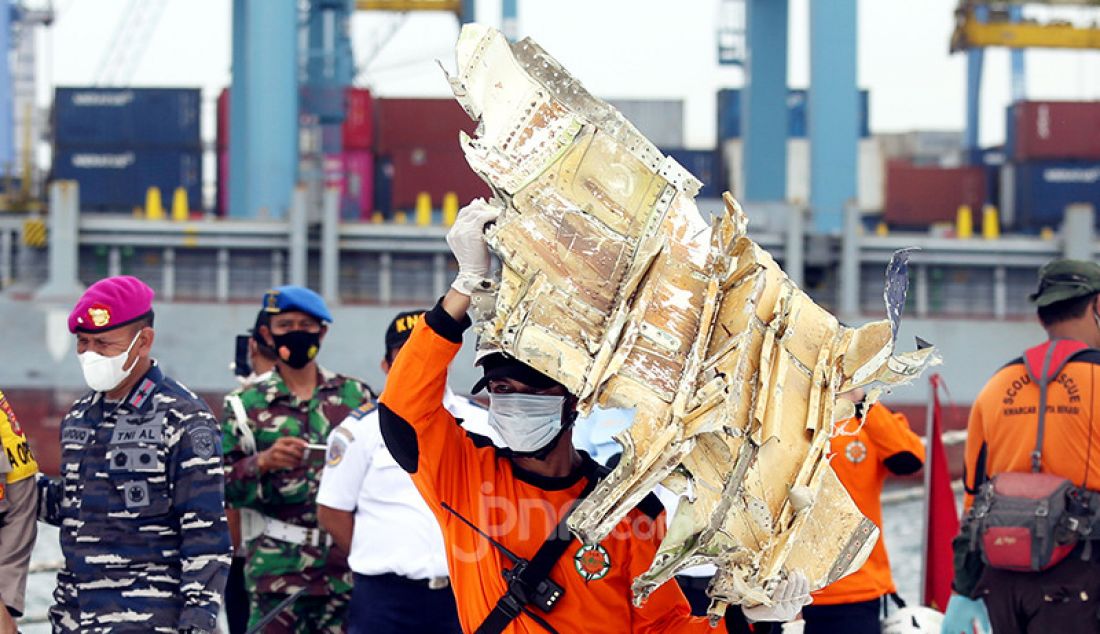 Petugas membawa serpihan pesawat Sriwijaya Air SJ182 di Dermaga JICT 2, Jakarta Utara, Senin (11/1). - JPNN.com