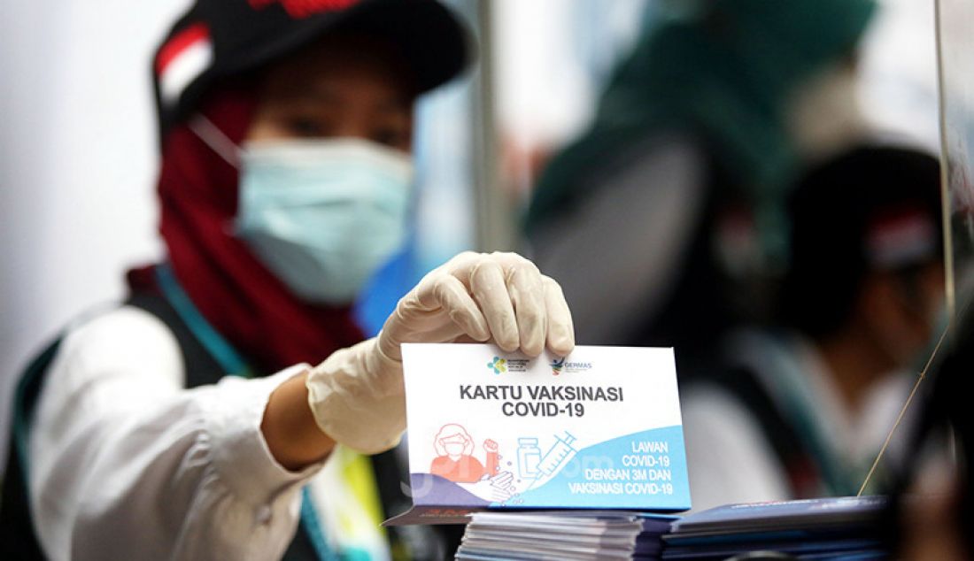 Tenaga kesehatan menunjukkan kartu vaksinasi Covid-19 di Puskesmas Tanah Sereal, Kota Bogor, Jawa Barat, Kamis (14/1). - JPNN.com