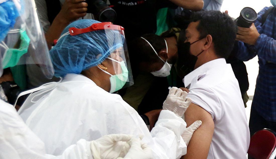Seorang petugas kesehatan di Puskesmas Tanah Sereal, Kota Bogor, Jawa Barat, Kamis (14/1), saat menerima suntikan vaksin Covid-19 buatan Sinovac, Tiongkok. - JPNN.com