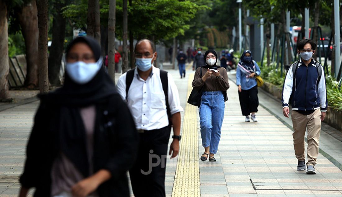 Warga usai pulang bekerja di trotoar jalan Jenderal Sudirman, Jakarta, Senin (25/1). Gubernur DKI Jakarta Anies Baswedan memperpanjang masa Pembatasan Sosial Berskala Besar (PSBB) ketat mulai 26 Januari hingga 8 Februari 2021. - JPNN.com