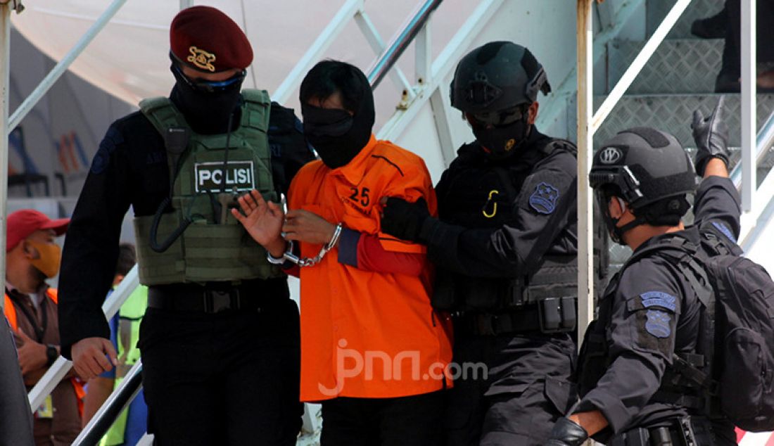 Anggota Detasemen Khusus 88 Antiteror Polri memegang terduga teroris menuruni tangga pesawat setibanya di Bandara Soekarno Hatta, Tangerang, Banten, Kamis (4/1). Polri memindahkan 26 terduga teroris dari Makassar dan Gorontalo ke Jakarta. - JPNN.com