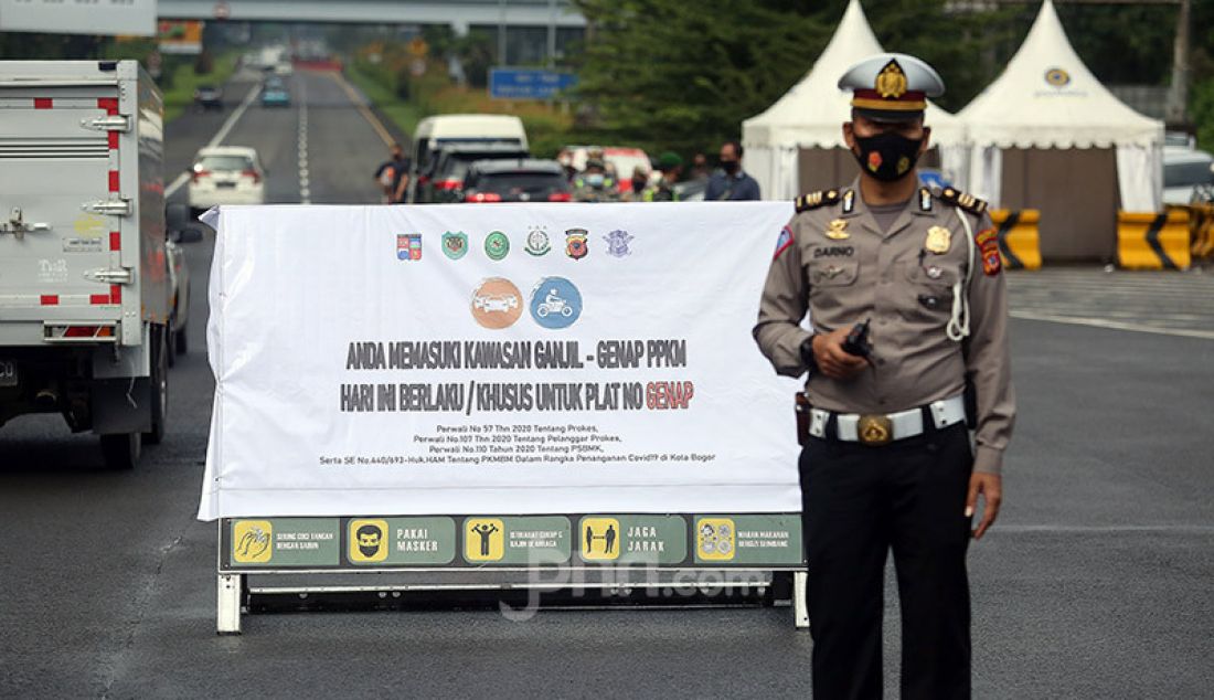 Petugas kepolisian memantau pelat nomor kendaraan di Kota Bogor, Sabtu (7/2). Pemerintah Kota Bogor memberlakukan sistem ganjil-genap pada 6-7 Februari 2021 dalam rangka mengurangi kerumunan dan mencegah penularan Covid-19. - JPNN.com