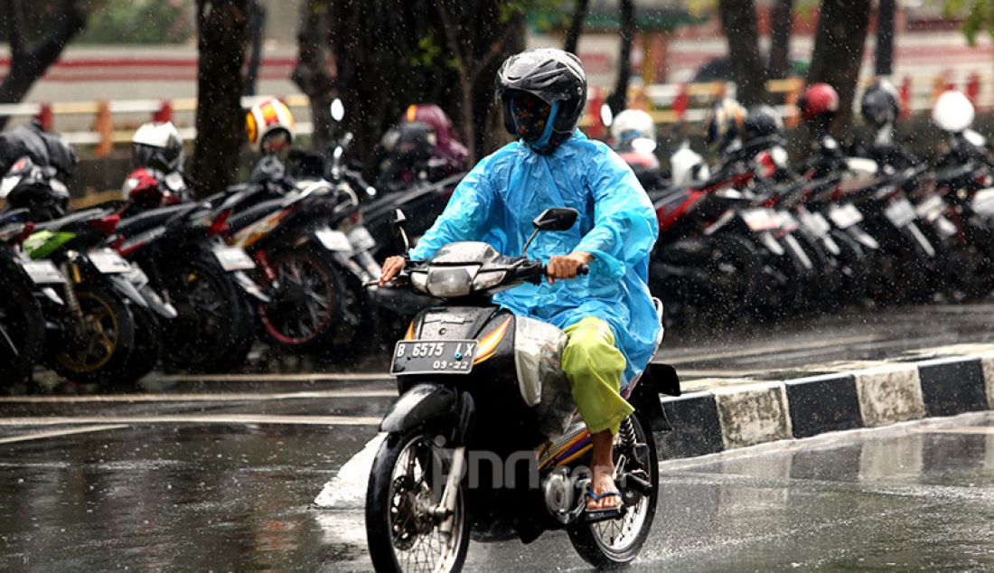 Pengguna sepeda motor mengenakan mantel melintasi kawasan Kuningan, Jakarta Selatan, Selasa (16/2). Badan Meteorologi, Klimatologi, dan Geofisika (BMKG) memprakirakan cuaca ekstrem akan melanda wilayah Jabodetabek pada 15-21 Februari 2021. - JPNN.com