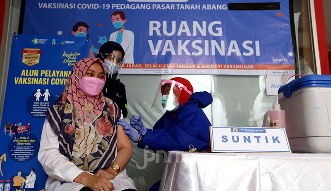 Tenaga kesehatan menyuntikkan vaksin Covid-19 kepada pedagang Blok A Pasar Tanah Abang, Jakarta Pusat, Rabu (17/2). Vaksinasi Covid-19 tahap dua ini dilakukan kepada 9.000 lebih pedagang yang terdaftar sebagai penerima vaksin. - JPNN.com