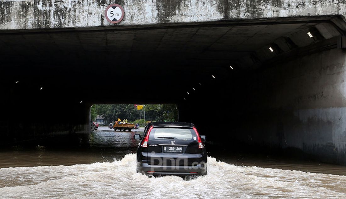 Kendaraan roda empat berusaha melewati banjir di Kelurahan Kebon Pala, Kecamatan Makassar, Jakarta Timur, Sabtu (20/2). Hujan yang mengguyur sejak Jumat (19/2) membuat sejumlah titik di Jakarta terendam banjir. - JPNN.com