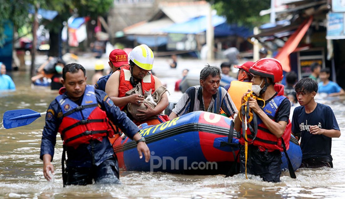 Petugas penyelamat mengevakuasi anak kucing yang terjebak banjir di Kelurahan Duren Tiga, Kecamatan Pancoran, Jakarta Selatab, Sabtu (20/2). Hujan yang mengguyur sejak Jumat (19/2) membuat sejumlah titik di Jakarta terendam banjir. - JPNN.com