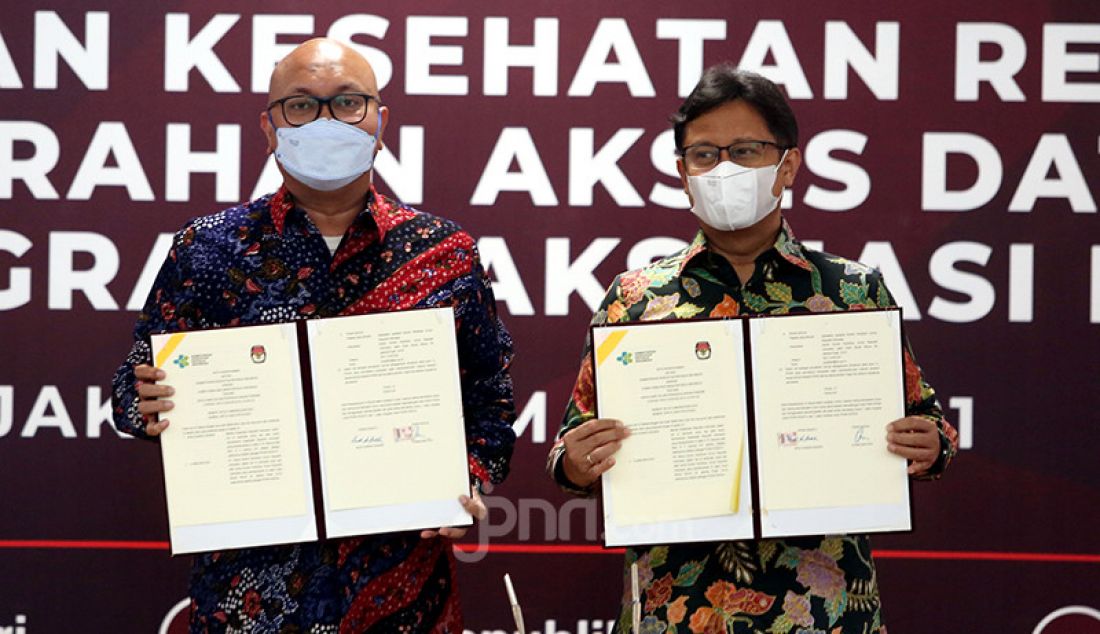 Pelaksana tugas (Plt) Ketua KPU RI Ilham Saputra (kiri) dan Menkes Budi Gunadi berfoto bersama di Jakarta, Selasa (2/3) usai penandatanganan kerja sama dalam rangka penanggulangan pandemi COVID-19 dan penyerahan akses data pemilih untuk Progam Vaksinasi Nasional. - JPNN.com