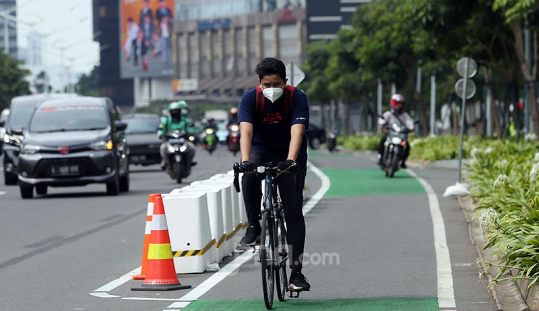 Pesepeda melintasi jalur sepeda sementara atau pop up bike line di Jalan Jenderal Sudirman, Jakarta, jumat (12/3). Direktorat Lalu Lintas Polda Metro Jaya berencana menilang pesepeda yang berkendara di luar jalur sepeda dengan denda Rp 100.000 atau ancaman kurungan 15 hari. - JPNN.com