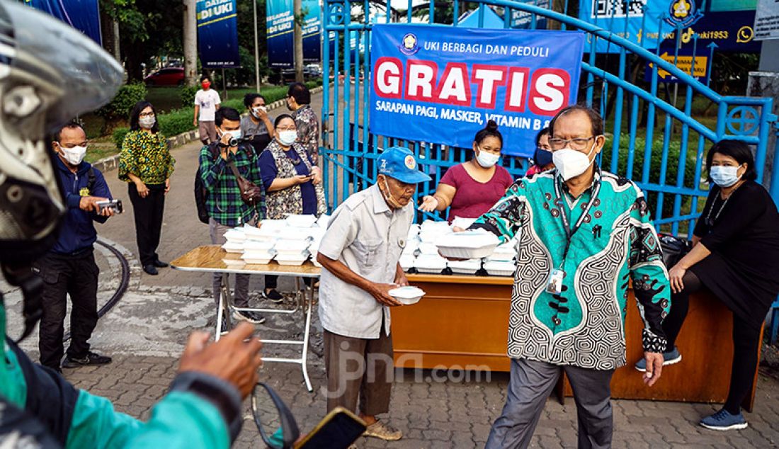 Sejumlah civitas akademi Universitas Kristen Indonesia menggelar kegiatan UKI Peduli dan Berbagi di sekitar kampusnya di Cawang, Jakarta Timur, Kamis (18/3). Melalui kegiatan itu, UKI membagikan makanan, masker, dan vitamin kepada warga yang melintas di sekitar kampus. - JPNN.com