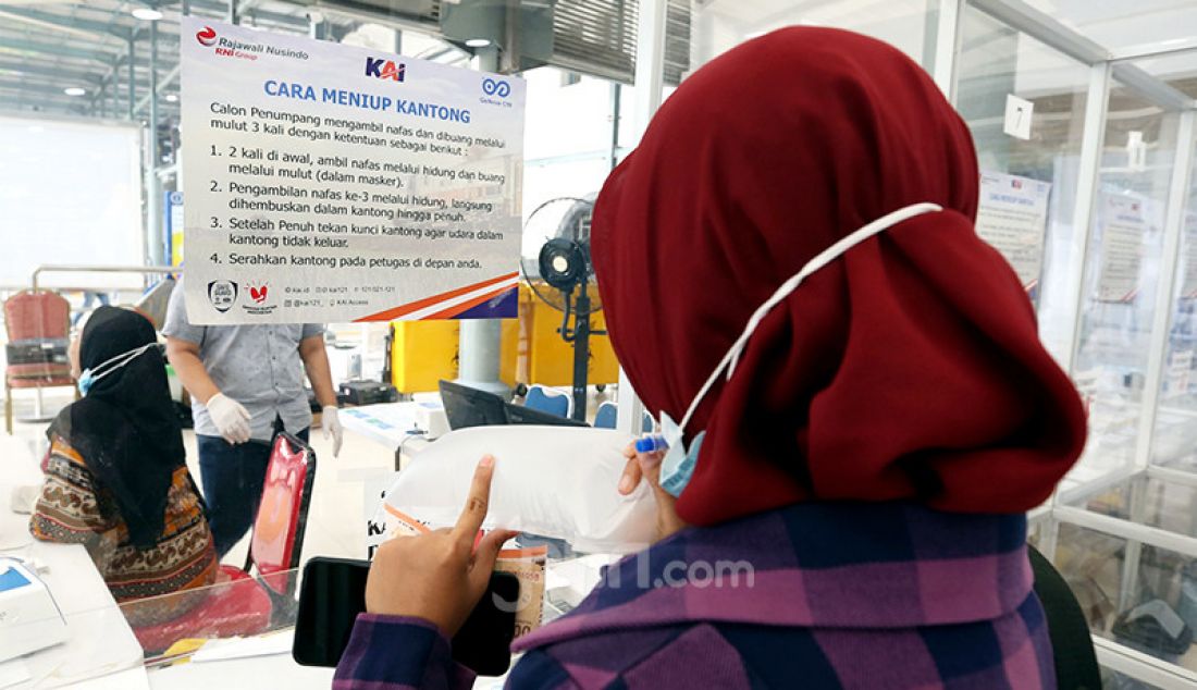 Calon penumpang kereta api di Stasiun Pasar Senen, Jakarta Pusat, meniup kantong udara untuk tes Covid-19 menggunakan GeNose C19, Rabu (24/3). PT KAI (Persero) menetapkan biaya penggunaan GeNose di sejumlah stasiun naik dari Rp 20 ribu menjadi Rp 30 ribu. - JPNN.com