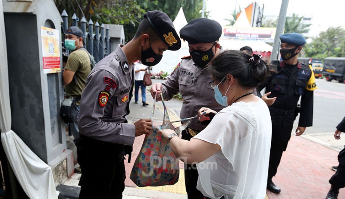 Petugas memeriksa barang bawaan warga yang memasuki Gereja Katedral, Jakarta, Kamis (1/4). Sebanyak 150 personel gabungan TNI, Polri, dan Satpol PP melakukan pengamanan jelang rangkaian perayaan Paskah. - JPNN.com